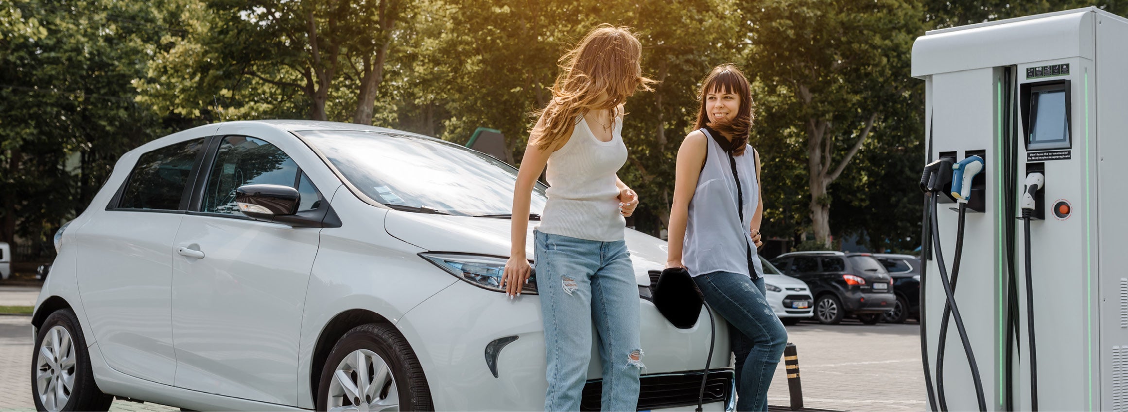 Young women charging their EV outside of their apartment complex